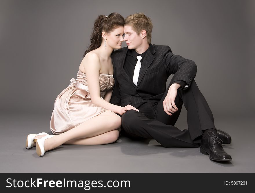 Portrait of a young beautiful couple on gray background