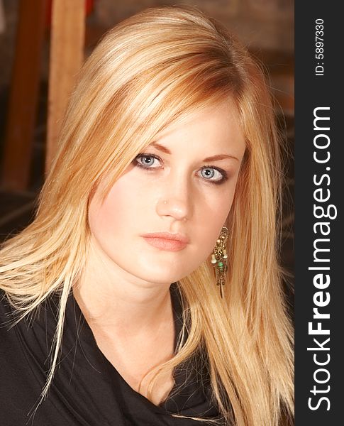 Portrait of Blonde beautiful girl with bright blue eyes and serious look in black top. Portrait of Blonde beautiful girl with bright blue eyes and serious look in black top