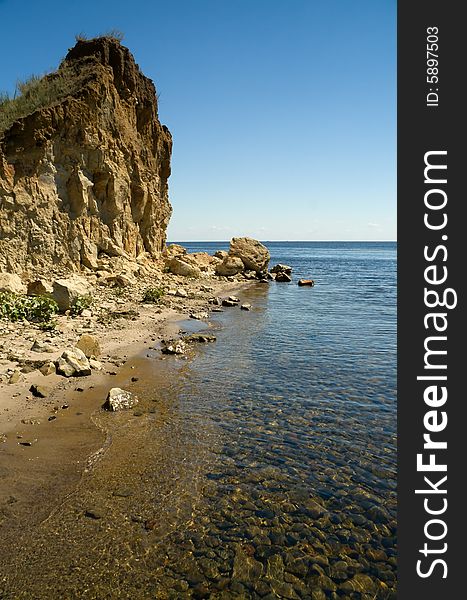 Sunny day at the beach desert. The sky, water, rocks, stones under water. Sunny day at the beach desert. The sky, water, rocks, stones under water.