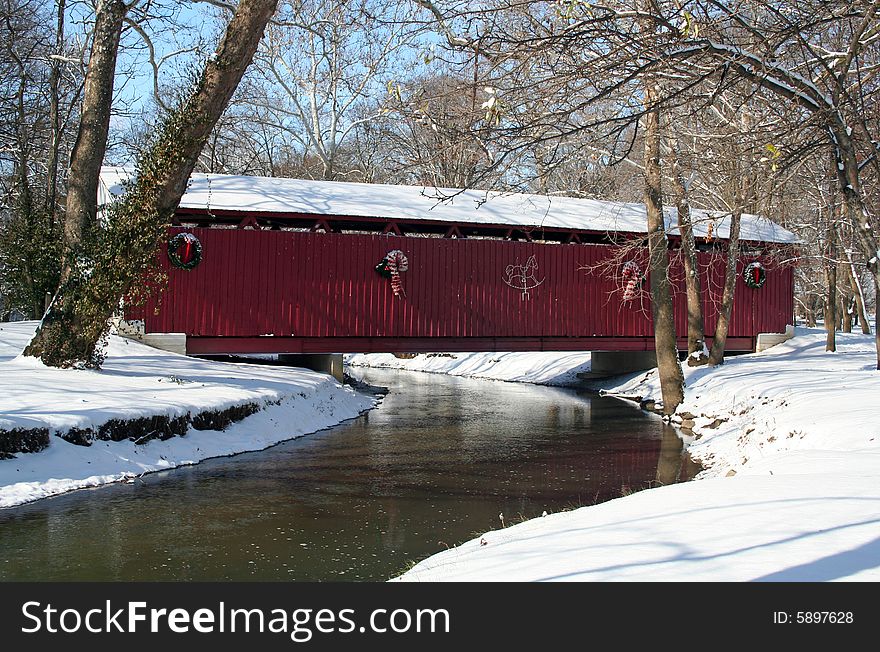 Old covered bridge after a snowfall decorated with christmas lights. Old covered bridge after a snowfall decorated with christmas lights