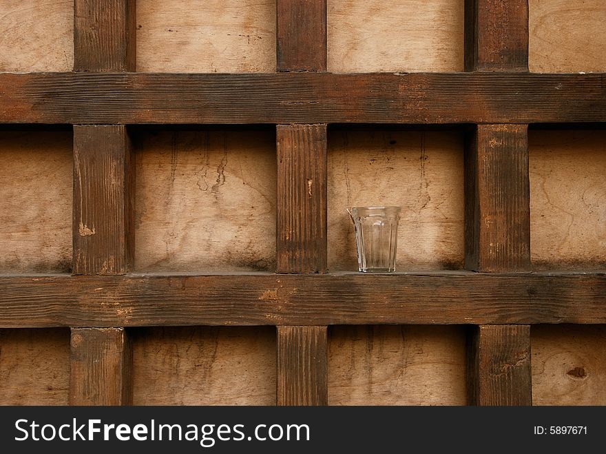 Glass on the structured wooden background. Glass on the structured wooden background