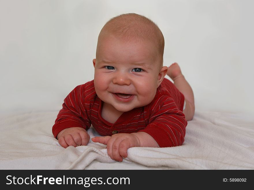 Newborn baby lift's up head with a smile. Boy is 4 months old. Newborn baby lift's up head with a smile. Boy is 4 months old