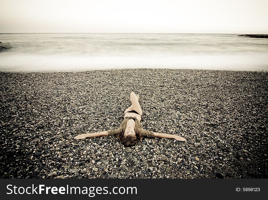 Crucified woman in stone beach, long exposure. Crucified woman in stone beach, long exposure