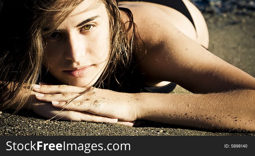 Green eyed beauty laying over the sand. Green eyed beauty laying over the sand