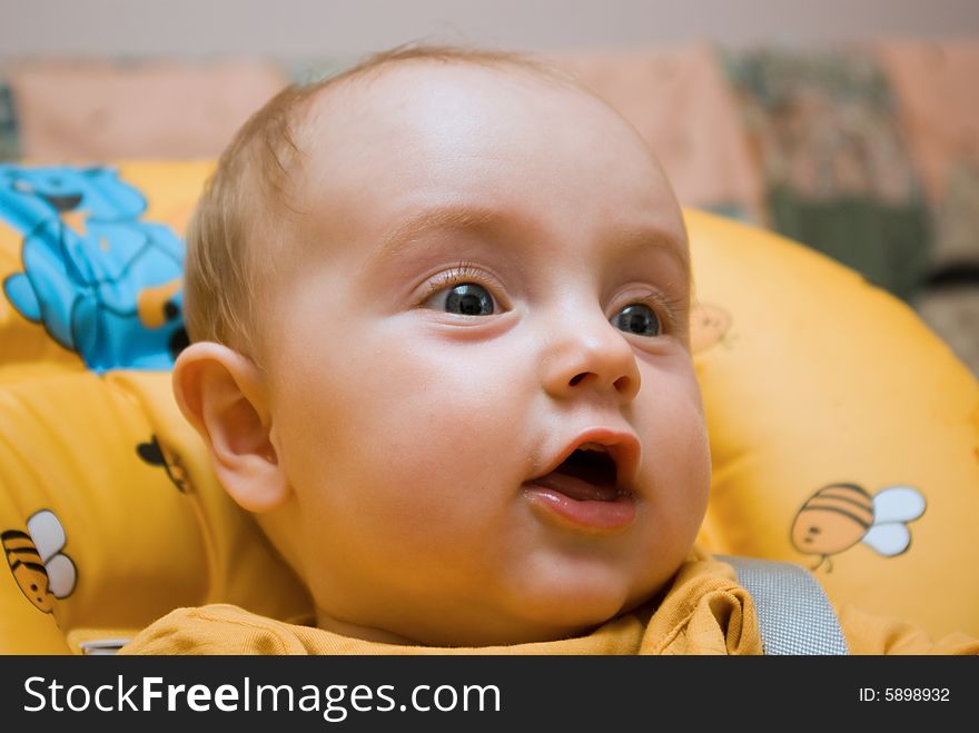 Little baby girl, sitting in a chair, looking happy and surprised. Little baby girl, sitting in a chair, looking happy and surprised