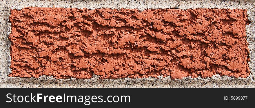 Single red brick surrounded by cement