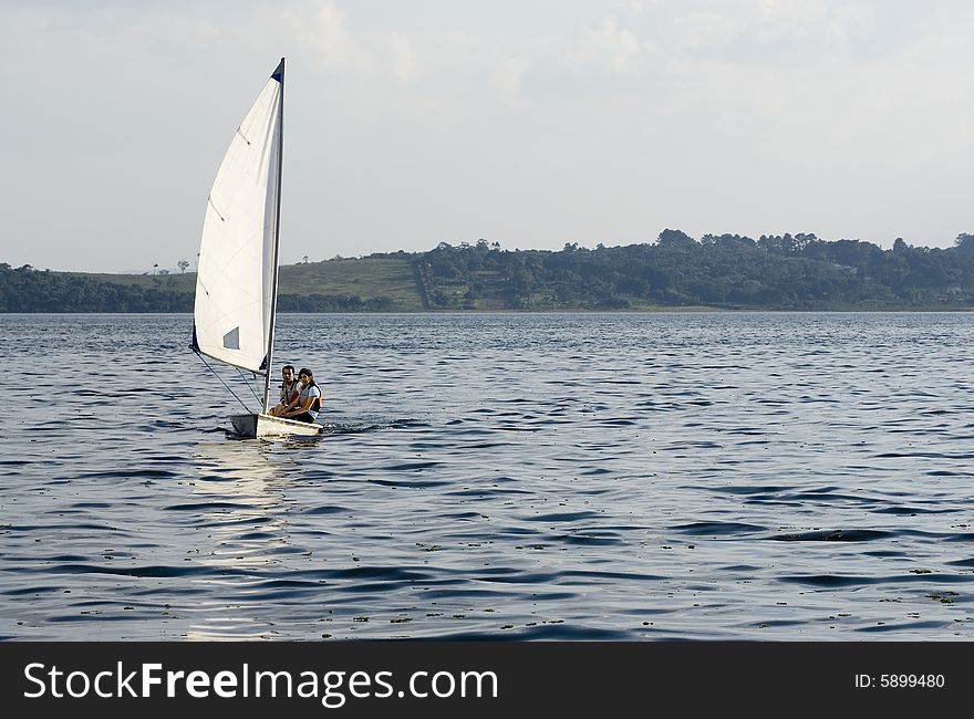 Man and woman sailing across lack towards camera. Horizontally framed photo. Man and woman sailing across lack towards camera. Horizontally framed photo.