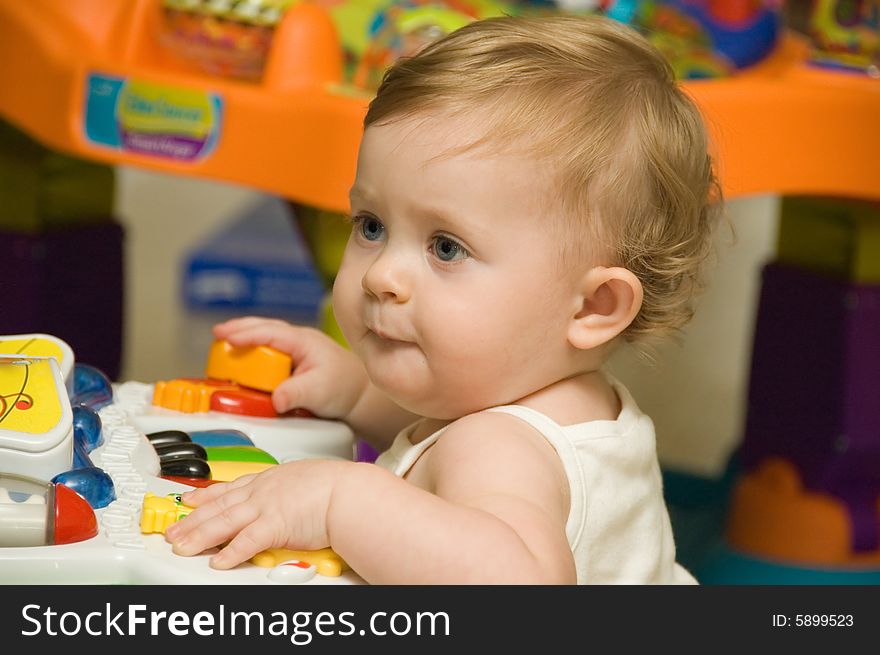 Portrait of blonde baby girl playing with musical toy. Portrait of blonde baby girl playing with musical toy.