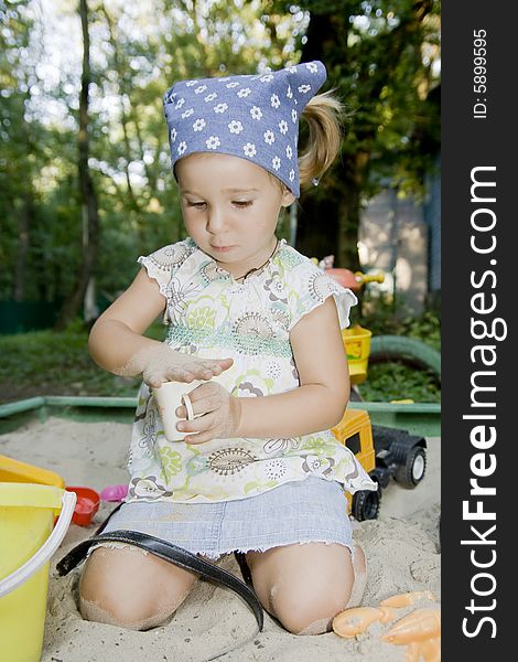 Little girl playing in sandbox