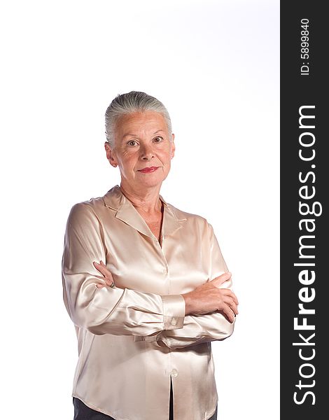 Portrait of senior female executive against white background arms folded