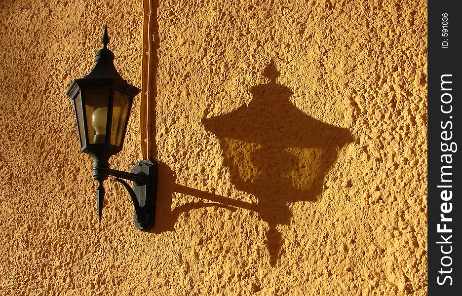 Lantern and his its shadow on a yellow wall. Lantern and his its shadow on a yellow wall