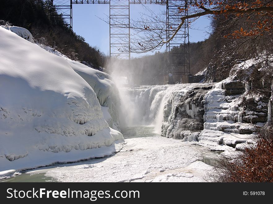 Partially frozen waterfalls with ice formations on the cliffs surrounding. Partially frozen waterfalls with ice formations on the cliffs surrounding