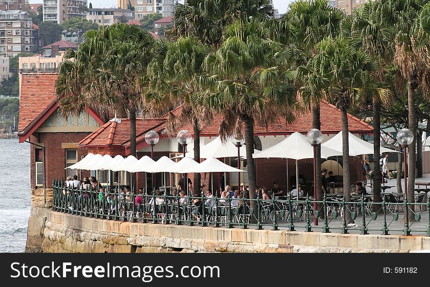 Bar terrace on sydney harbour, with people having a drink