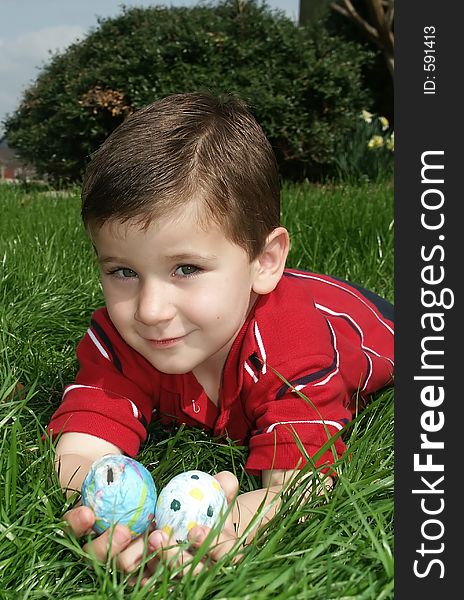 A young boy showing off two Easter eggs. A young boy showing off two Easter eggs.