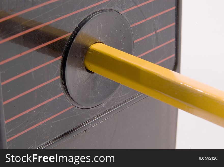 A close up view of a pencil inserted in an electric sharpener. A close up view of a pencil inserted in an electric sharpener