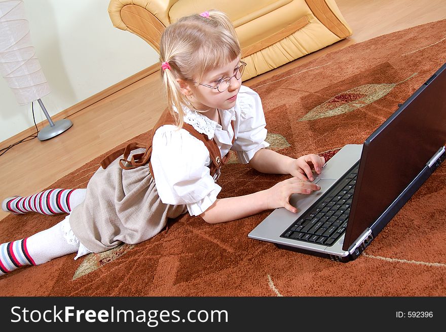 Little girl with laptop on the floor