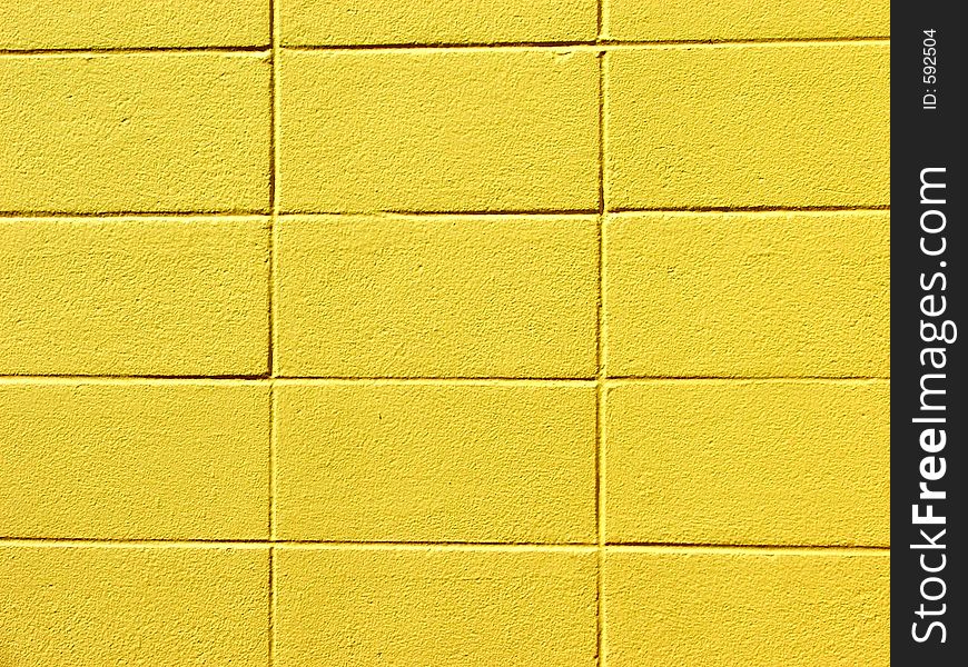 Yellow-painted concrete block wall. Yellow-painted concrete block wall