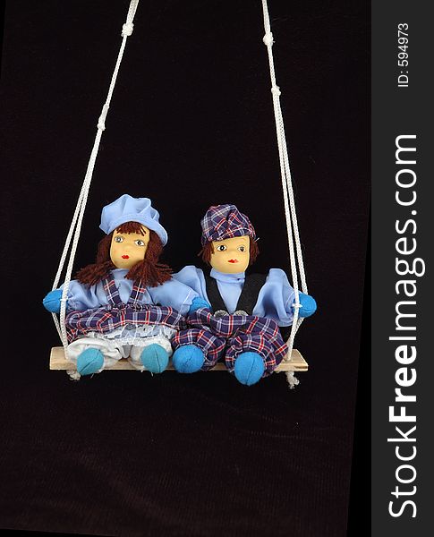 A boy and girl doll on a swing. A boy and girl doll on a swing