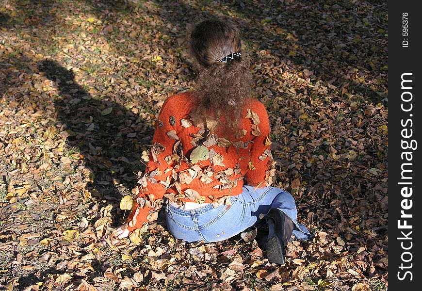 Girl with autumn leaves on her back