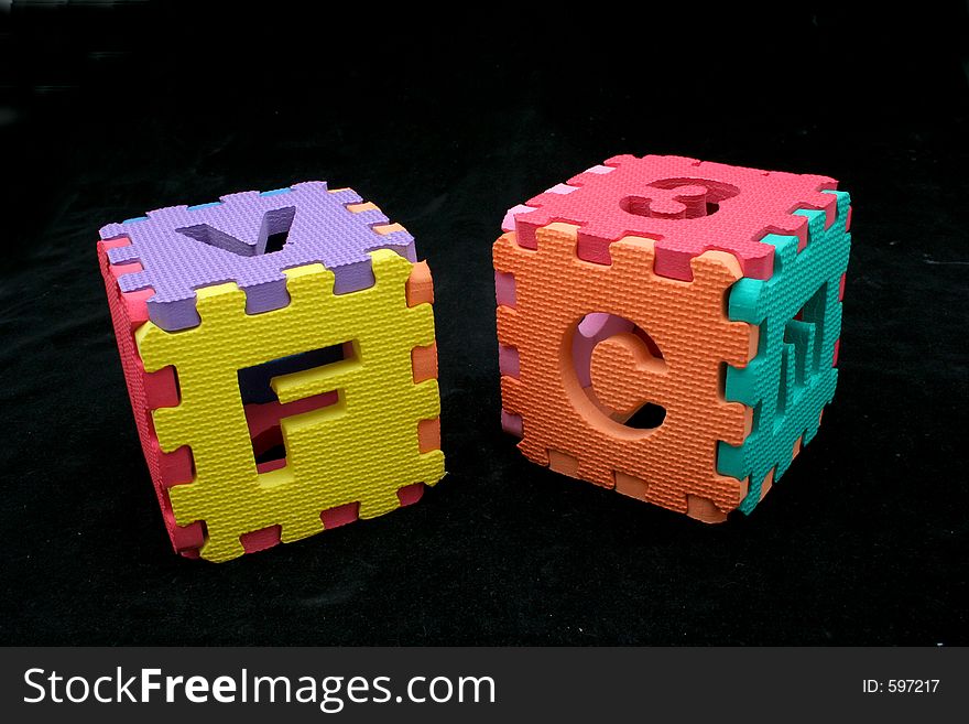 Puzzle cubes with letters and numbers over a black backgrund