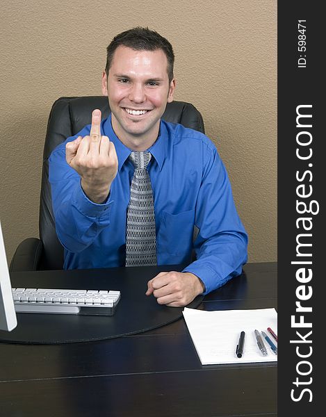 Angry employee giving the finger with a fake and forced smile on his face. Angry employee giving the finger with a fake and forced smile on his face