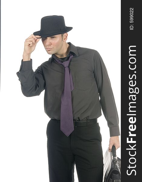 Young, attractive male model dressed soberly on tie, hat and briefcase poses in a cool stance over white. Young, attractive male model dressed soberly on tie, hat and briefcase poses in a cool stance over white