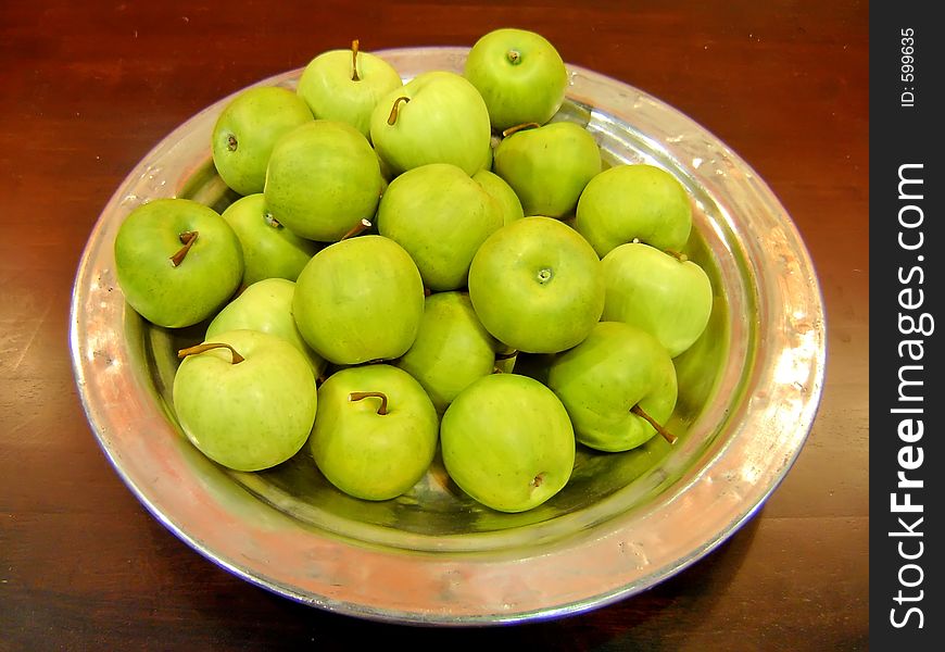 Green apples in metal plate