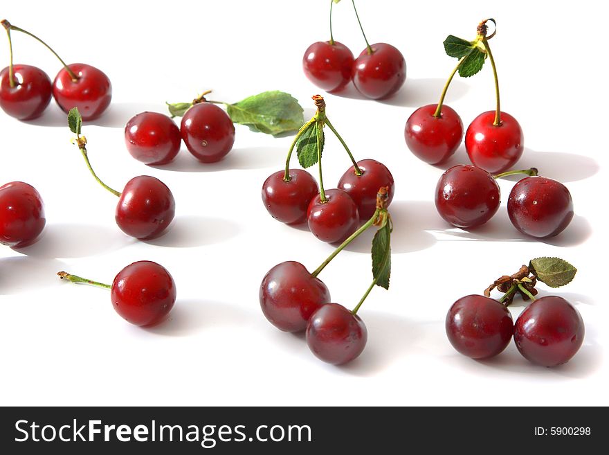 Ripe berries of a cherry of red color and their shadow on light background.