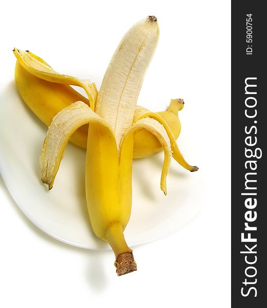 A peeled and an unpeeled fresh banana on white plate and isolated on white background. A peeled and an unpeeled fresh banana on white plate and isolated on white background