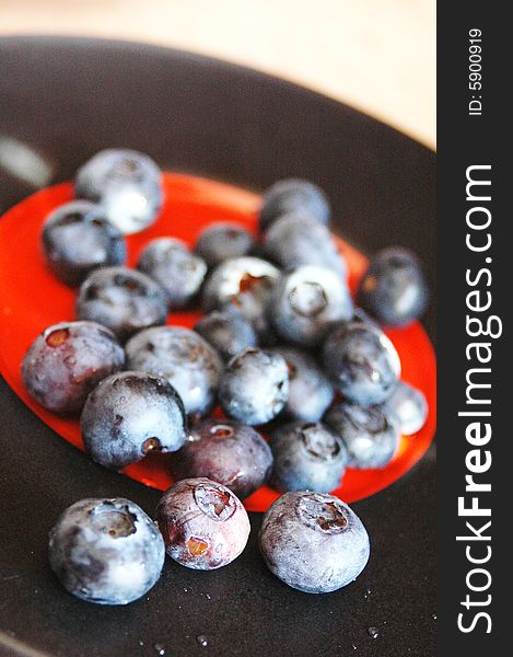 Fresh ripe blueberries on a black and red plate
