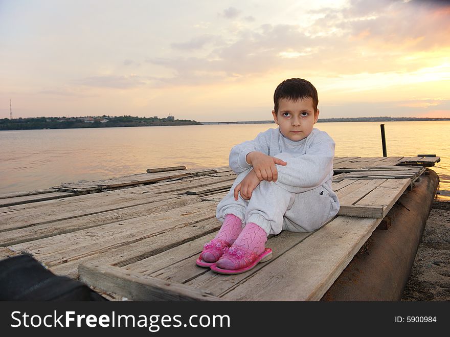 Pretty child on sunset background