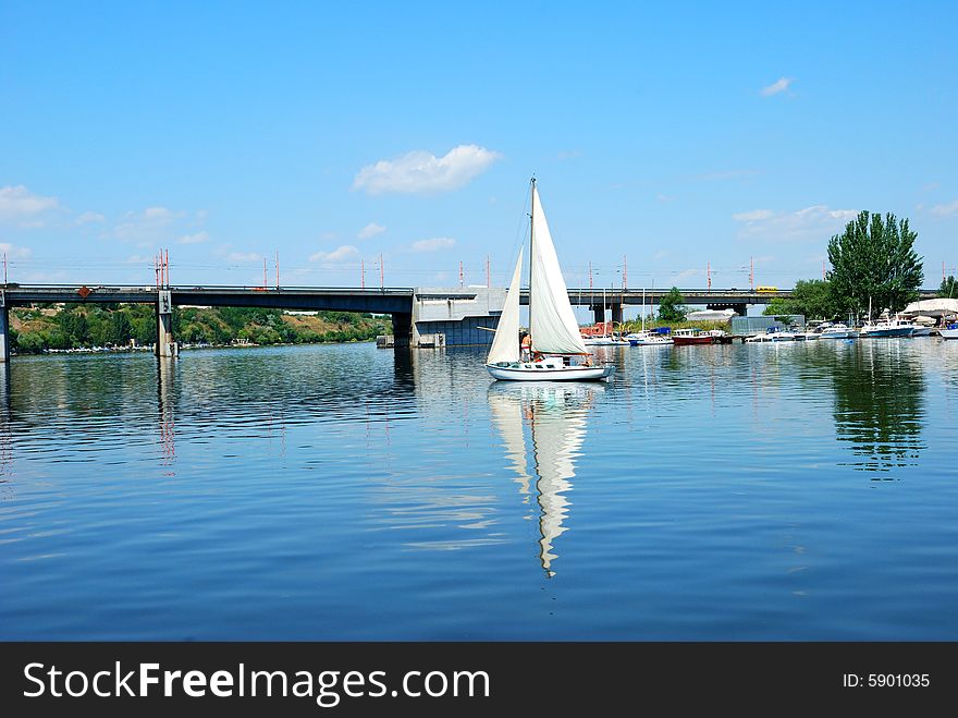 Calm river and sailing over city bridge. Calm river and sailing over city bridge