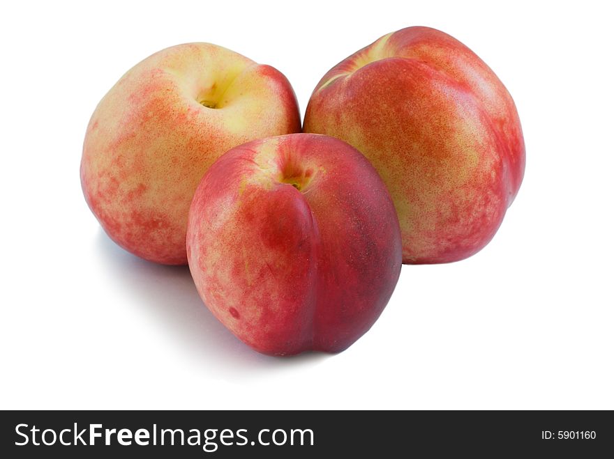 Three ripe peaches on a white background