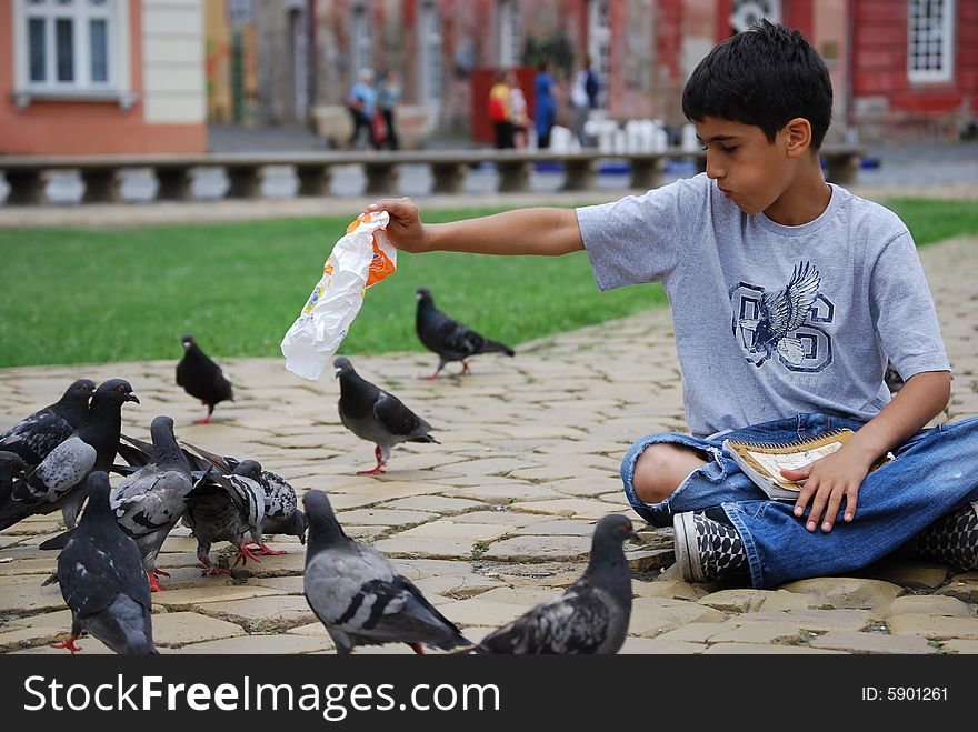 Sharing food with pigeons in the city square