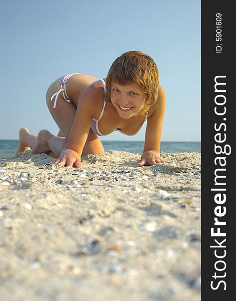 Young beautiful woman on sea beach wearing swimsuit