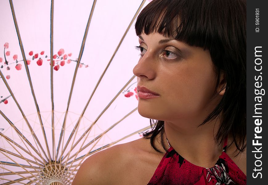 Beautiful young lady with asian umbrella staring