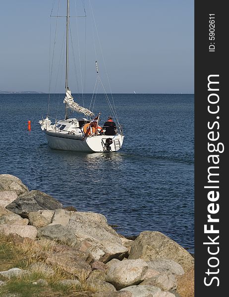 Sailing boat passing buoy outside Norsminde Harbour, Denmark