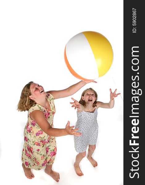 Two girls tossing ball in air