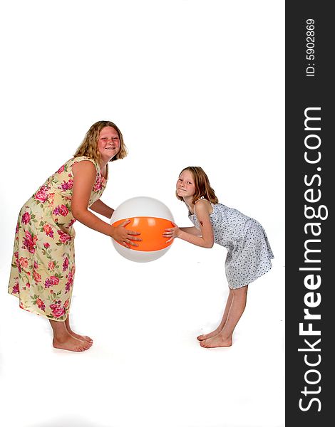 Sisters in dresses holding beach ball. Sisters in dresses holding beach ball