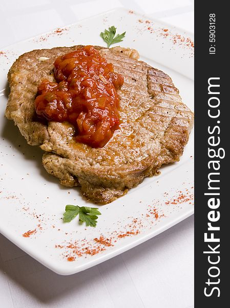Meal cutlet with tomatoes sauce on white plate