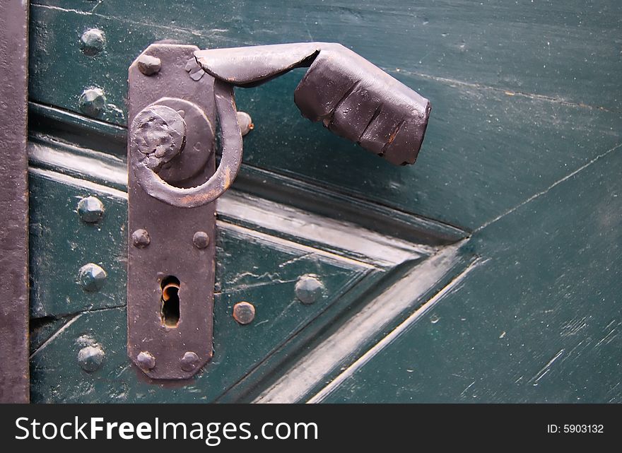 Old rusty door handle, green door