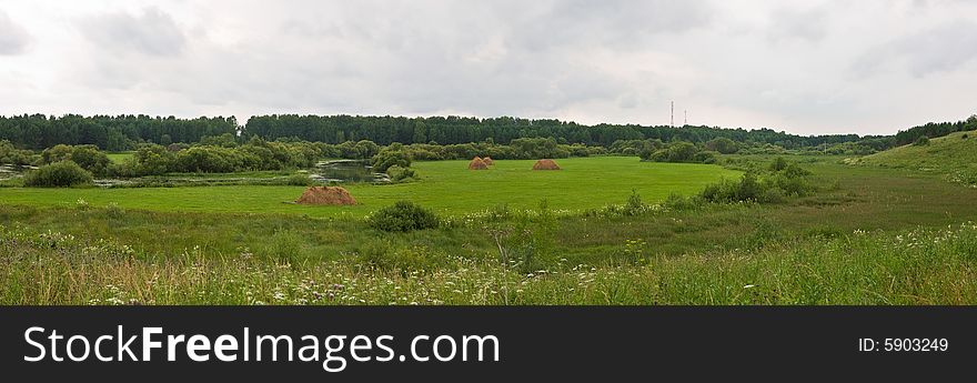 Rural scene with haystack on the meadow