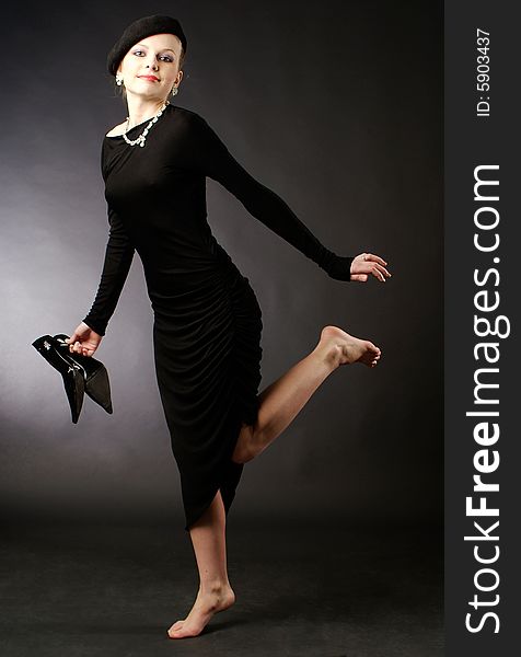 Young beautiful woman barefoot in black dress. Young beautiful woman barefoot in black dress