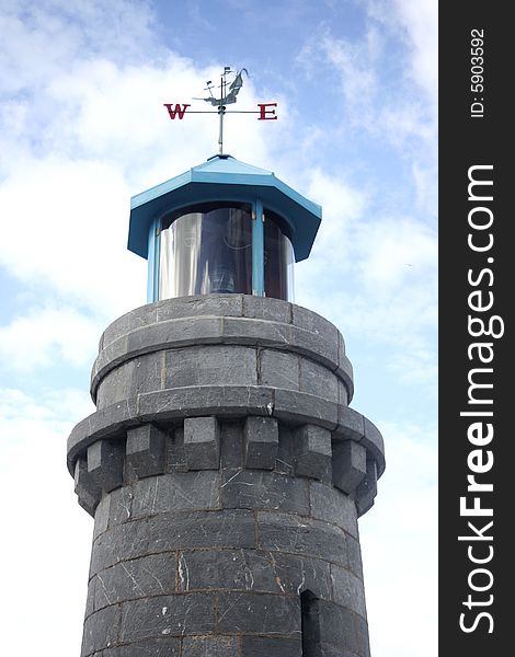 Old stone lighthouse with weathervane. Old stone lighthouse with weathervane.
