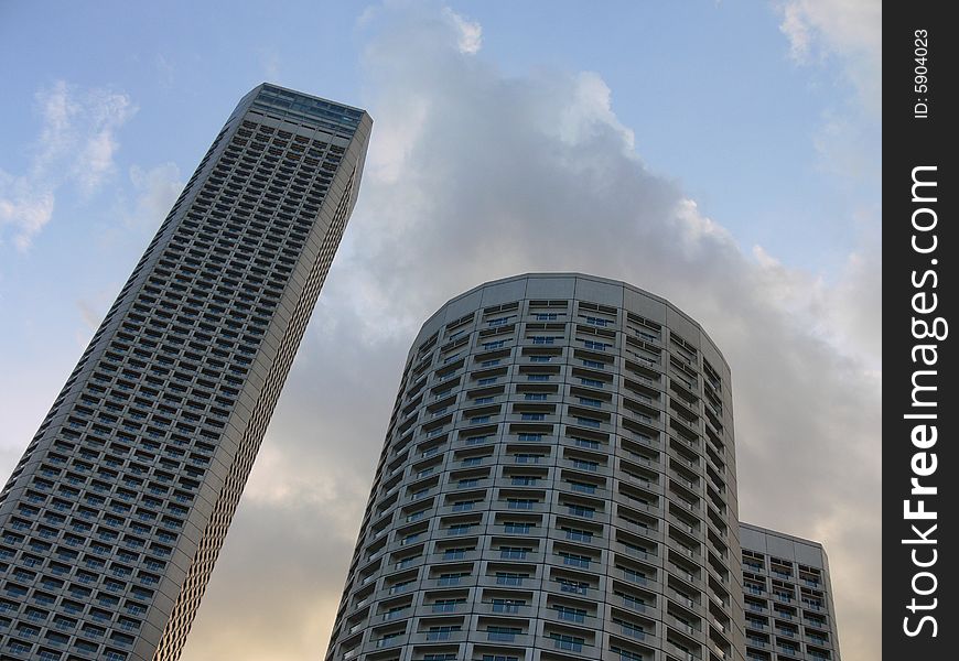 Modern buildings in singapore in front of a blue sky with clouds