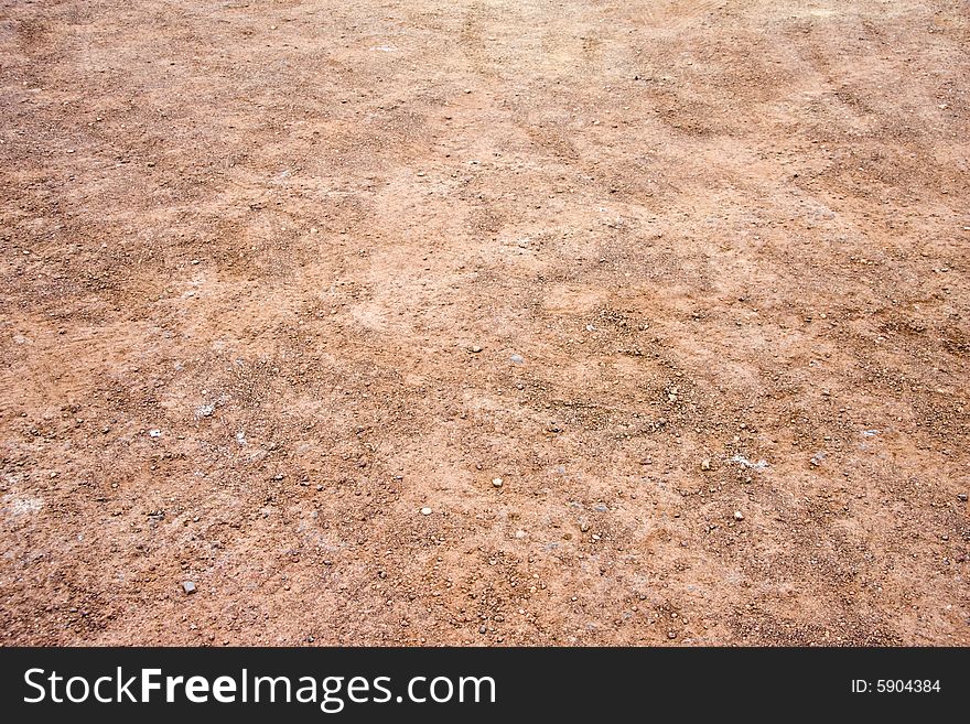 Red and orange gravel with tire tracks