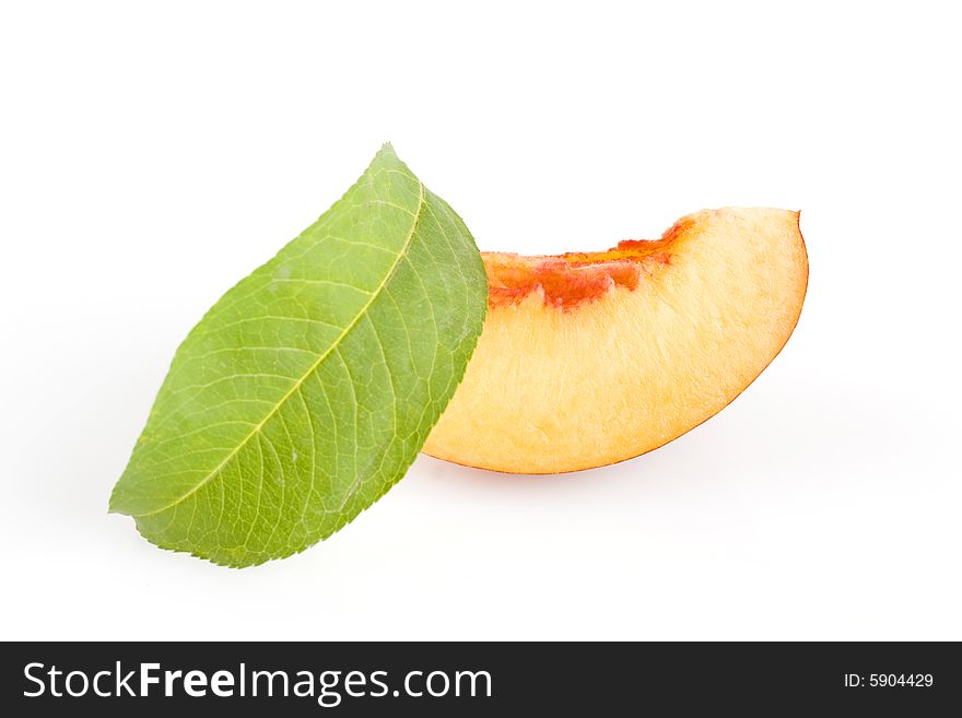 Ripe sliced peach fruit with green leaf isolated on white background. Ripe sliced peach fruit with green leaf isolated on white background