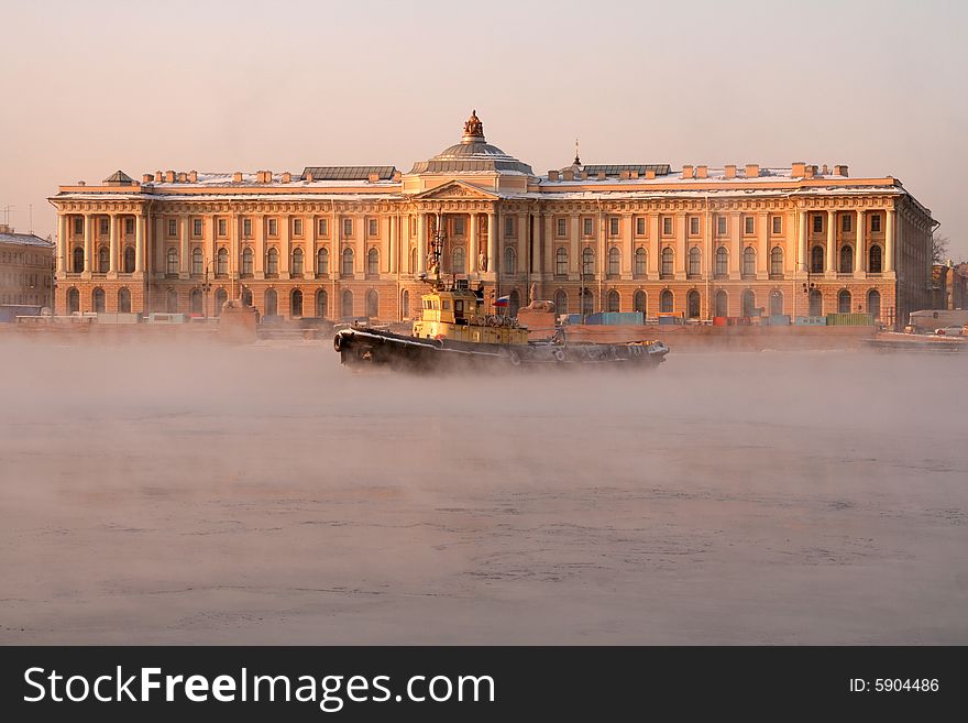 A small yellow ice breaker on a river. A small yellow ice breaker on a river