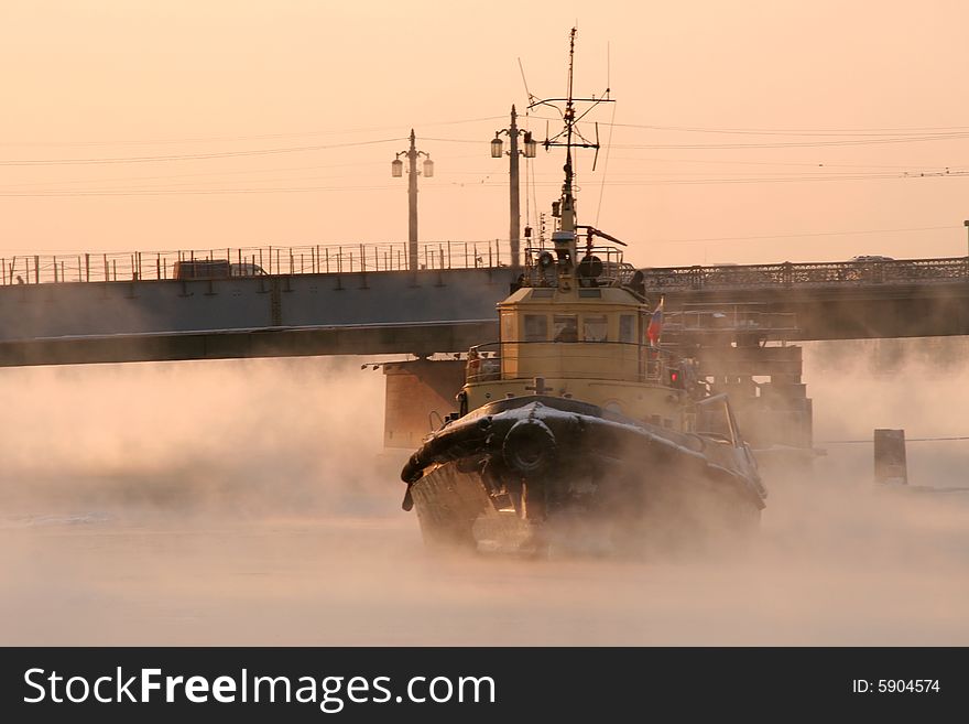 A small river ice breaker under a bridge