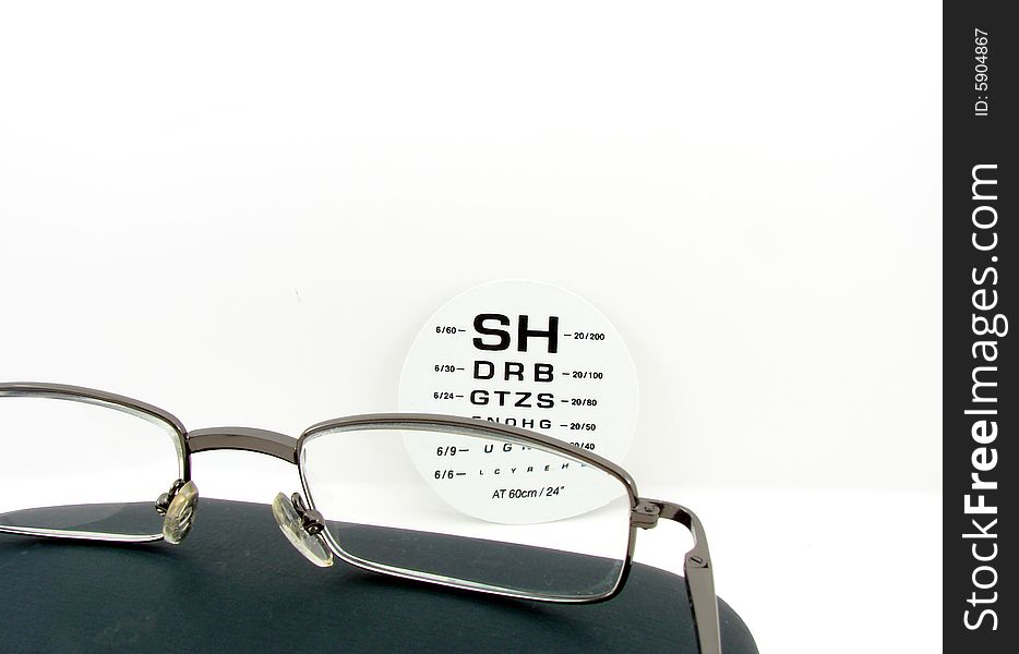 Glasses and eye test isolated over white background, at the optician.